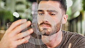 Young man outside at night watching video on phone