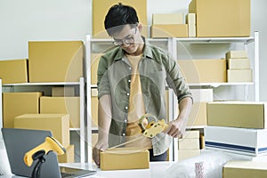Young man packing product in box for online order. .