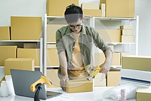 Young man packing product in box for online order. .