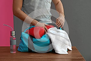 Young man packing sports bag