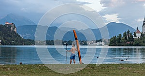 Young man with paddle board on the lake