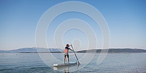 Young man paddling on a sup board