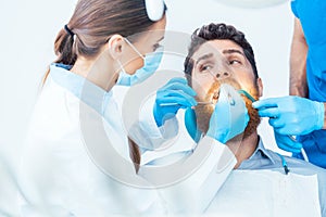 Young man during a painless oral procedure in the dental office