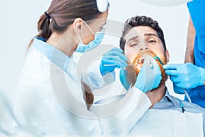 Young man during a painless oral procedure in the dental office