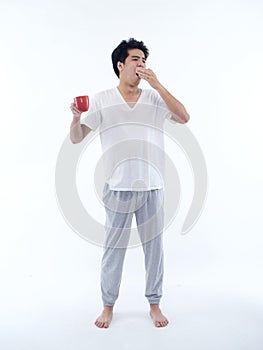 Young man in pajamas with cup of coffee