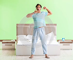 Young man in pajamas doing morning exercises
