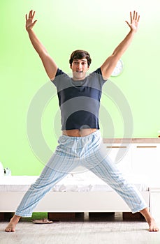 Young man in pajamas doing morning exercises