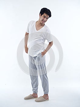 Young man in pajamas on white background