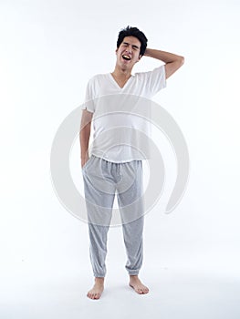 Young man in pajamas on white background