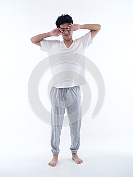 Young man in pajamas on white background