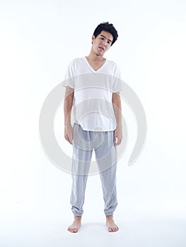 Young man in pajamas on white background