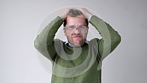 The young man with a panic attack is desperately tearing his hair on his head