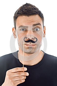 Young man with paper moustaches making faces isolated on white b photo