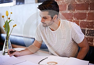 Young man, paperwork and coffee shop with documents for planning, reading or finance at indoor restaurant. Male person