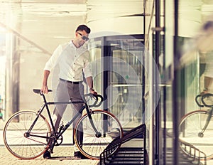 Young man parking his bicycle on city street