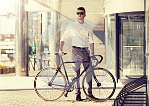 Young man parking his bicycle on city street