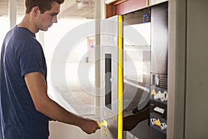 Young Man Paying For Car Parking At Machine