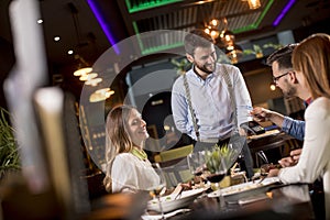 Young man paying with contactless credit card in the restaurant