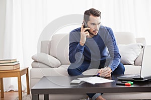 Young man paying his bills with laptop