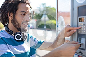 young man paying ticket on parking meter