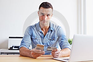 Young man pays by credit card with his mobile phone