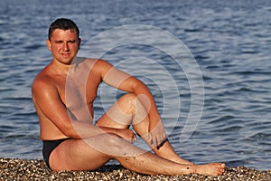 Young man on pebble beach