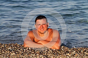 Young man on pebble beach