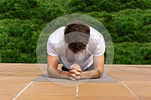 Young man performing some workouts at his home terrace