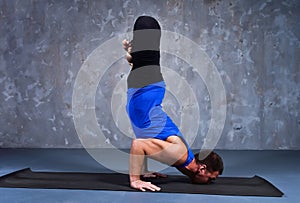 Young man performs Urdhva padma vrikshasana