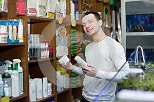 Young man with pet supplements in petshop