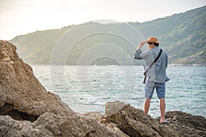 Young man photographer standing on the rock