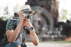 Young Man Photographer Traveler with backpack taking photo with his camera, Great wall in background at historical place.