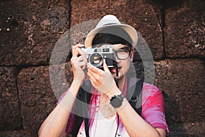 Young Man Photographer Traveler with backpack taking photo with his camera, Great wall in background at historical place.