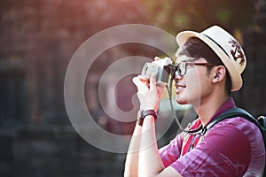 Young Man Photographer Traveler with backpack taking photo with his camera, Great wall in background at historical place.