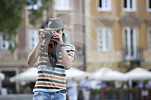 Young man photographing through vintage camera outdoors