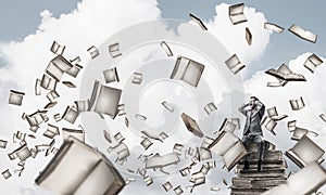 Young man on pile of books dont want to hear anything