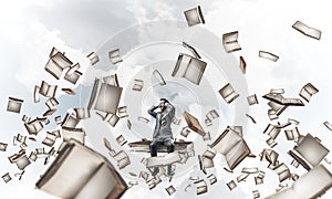 Young man on pile of books dont want to hear anything