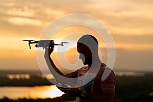 Young man piloting a drone in the evening