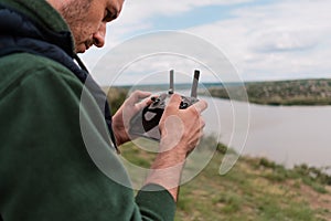 Young man piloting a drone in nature