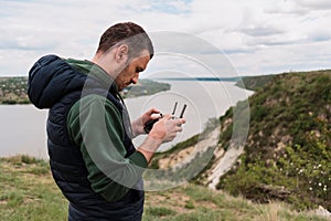 Young man piloting a drone in nature