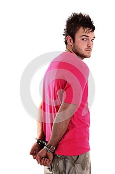 Young man in pink shirt with handcuffs