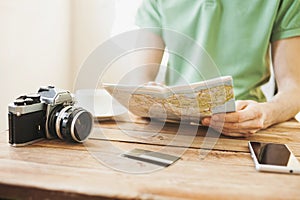 Young man planning vacation trip with travel map