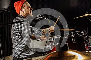 Young man play on drums and sing