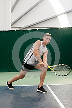 Young man play tennis outdoor on orange court