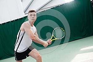 Young man play tennis outdoor on orange court