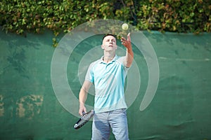 Young man play tennis outdoor on orange court