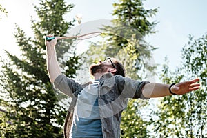 Young man playing badminton outdoors in the park. Concept of an active and healthy lifestyle