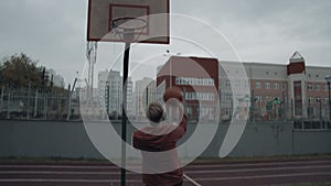 Young man playing basketball outdoors on the court