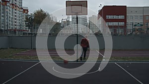 Young man playing basketball outdoors on the court