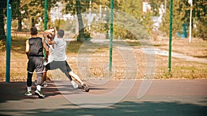 Young man playing basketball on the sports ground with friends - getting a score